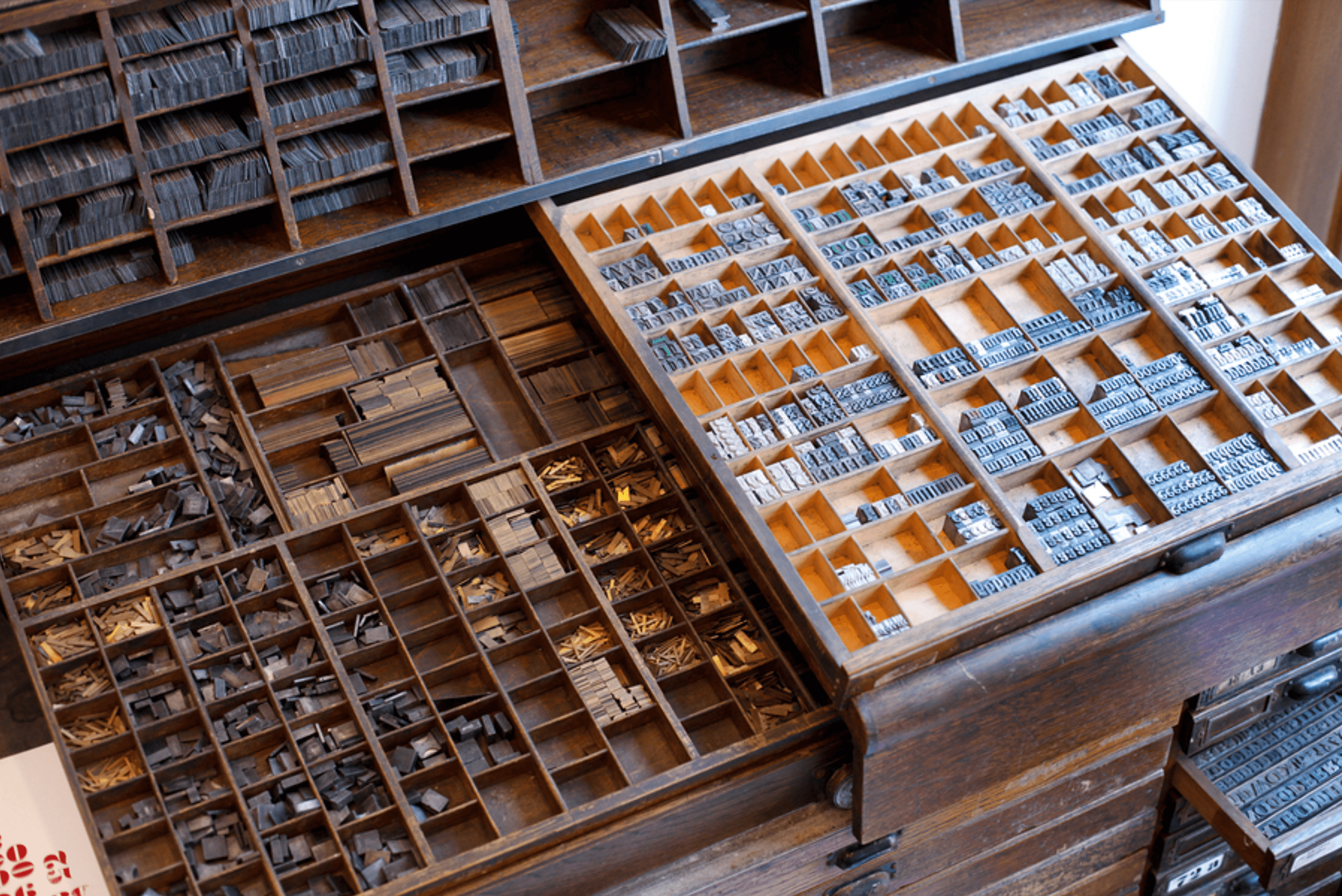 A box of metal movable type characters sorted by letter