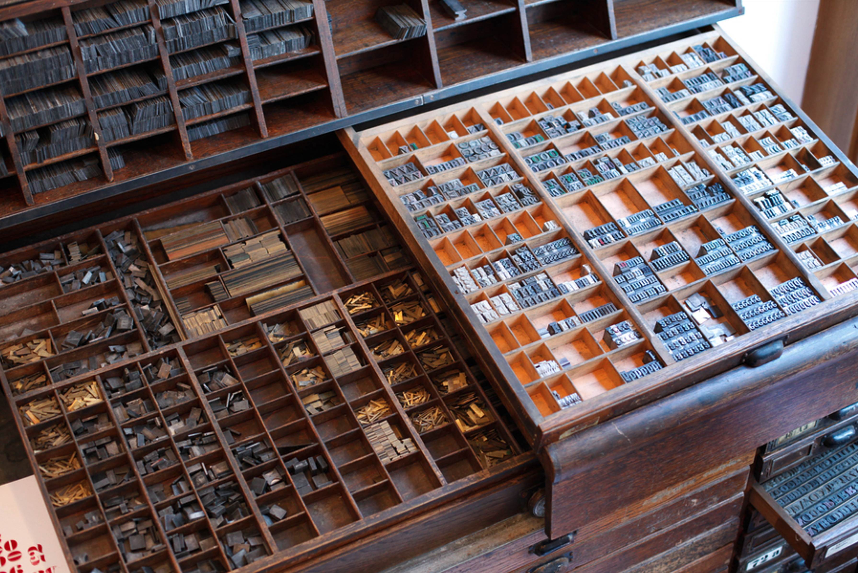 A box of metal movable type characters sorted by letter